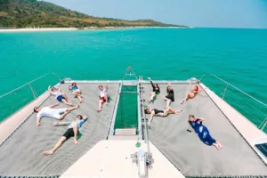 people relaxing on sunbathing net on samui luxury party catamaran