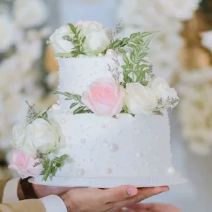 wedding cake for celebration on the boat with white and pink roses